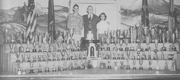 Billy Walker, Cecil Fain, and Martha Green surrounded by trophies
